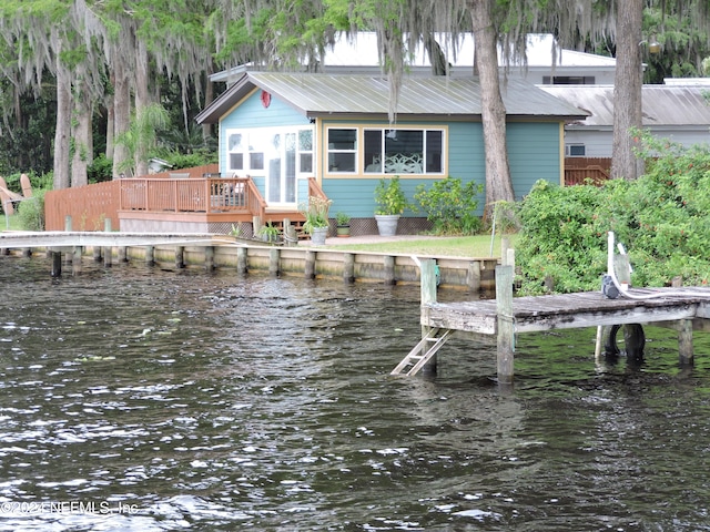 rear view of house featuring a deck with water view