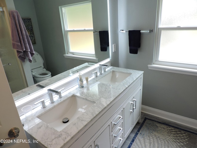 bathroom with double sink vanity and toilet