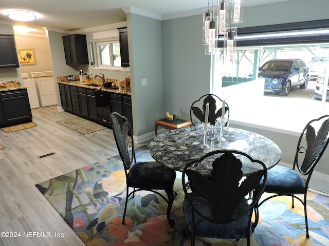 dining area with ornamental molding, light hardwood / wood-style floors, separate washer and dryer, and sink