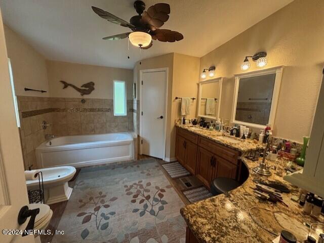 bathroom featuring ceiling fan, vanity, and vaulted ceiling