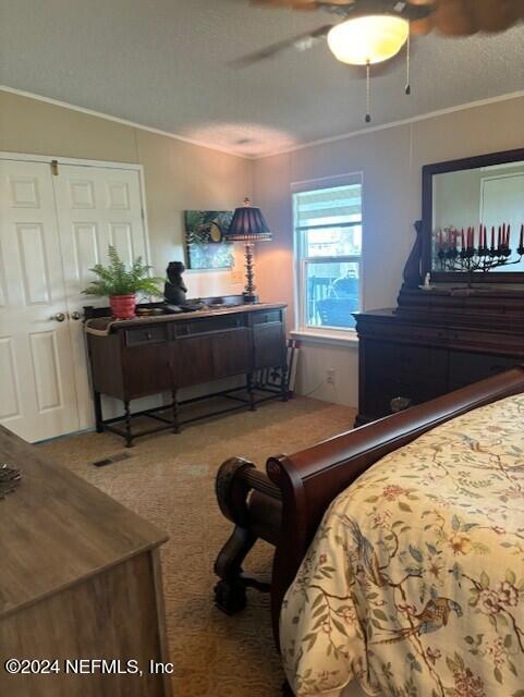 carpeted bedroom featuring ceiling fan and ornamental molding