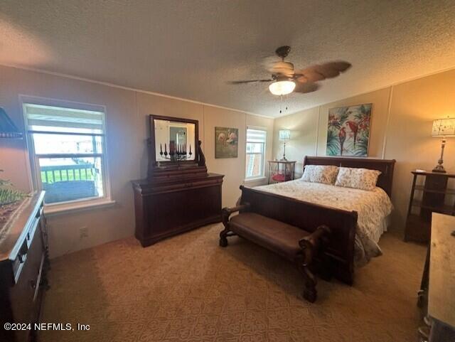 bedroom featuring a textured ceiling, ceiling fan, and carpet