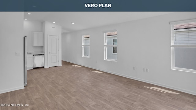 unfurnished room with vaulted ceiling and light wood-type flooring