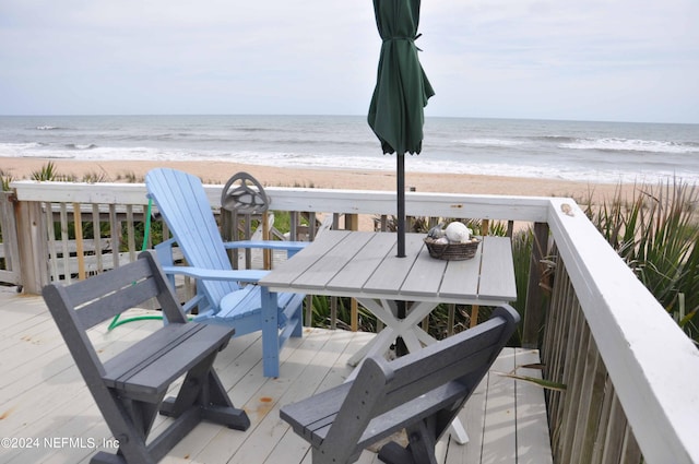 wooden deck featuring a water view and a view of the beach