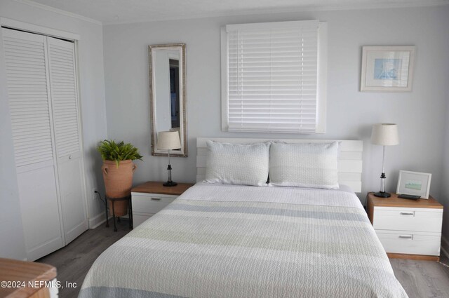 bedroom with ornamental molding, a closet, and light wood-type flooring