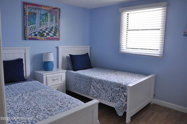 bedroom with dark hardwood / wood-style floors