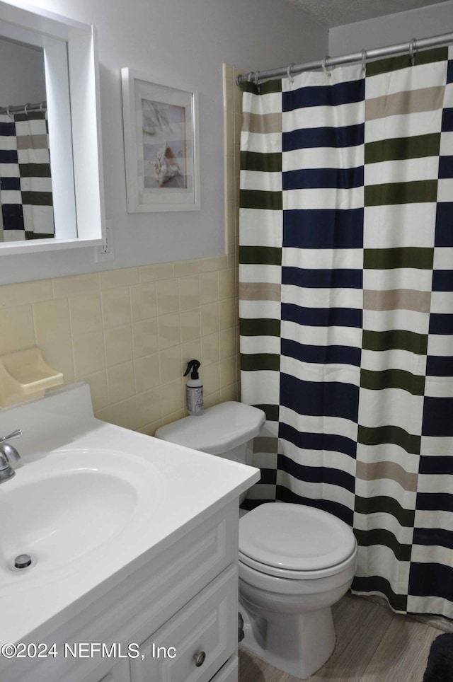 bathroom featuring tile walls, vanity, wood-type flooring, curtained shower, and toilet