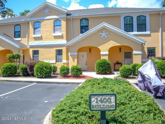 multi unit property with uncovered parking and stucco siding