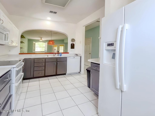 kitchen with white cabinets, white appliances, sink, kitchen peninsula, and light tile patterned floors