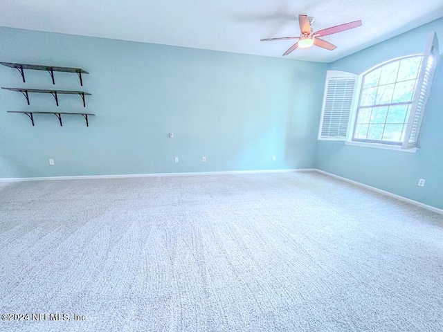 carpeted empty room with ceiling fan and vaulted ceiling