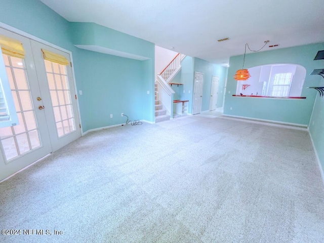 unfurnished living room with carpet flooring and french doors