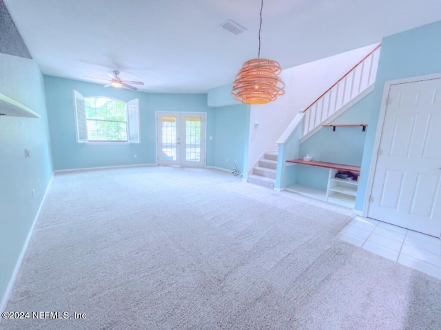 unfurnished living room featuring built in features, light colored carpet, french doors, and ceiling fan