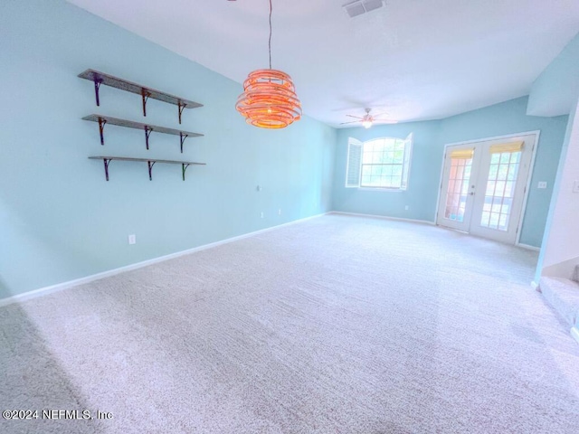 carpeted spare room featuring french doors and ceiling fan