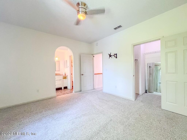 unfurnished bedroom with ceiling fan, connected bathroom, and carpet flooring