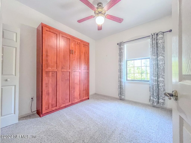 unfurnished bedroom featuring light carpet and ceiling fan