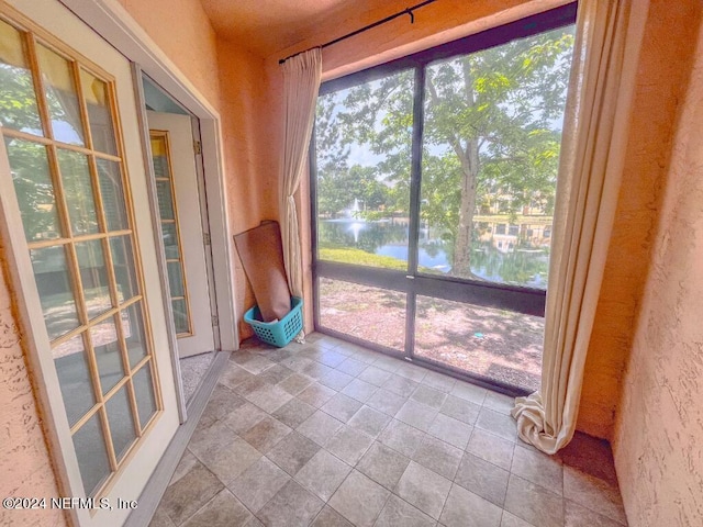 unfurnished sunroom with a water view and a wealth of natural light