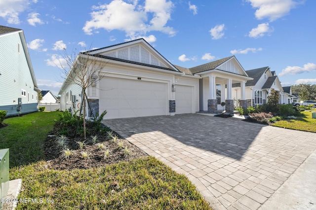 view of front of property featuring a garage, covered porch, and a front lawn