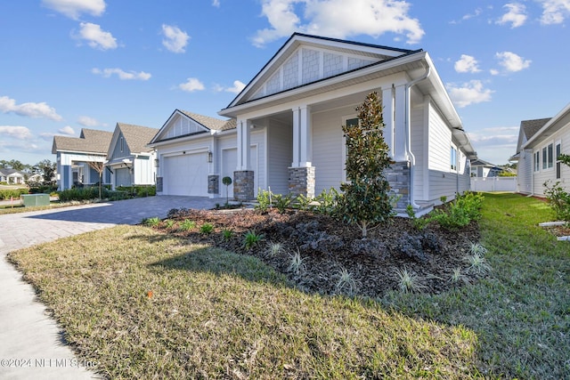 view of front of house with a front lawn, covered porch, and a garage