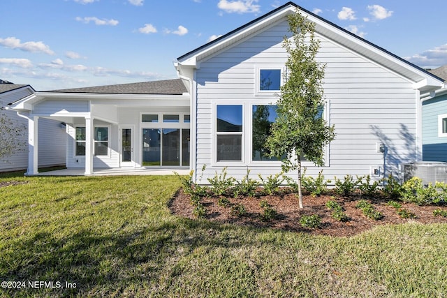 back of property with central AC, a lawn, and a patio