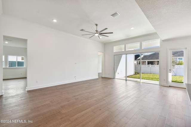 unfurnished living room with ceiling fan, wood-type flooring, a textured ceiling, and ornamental molding