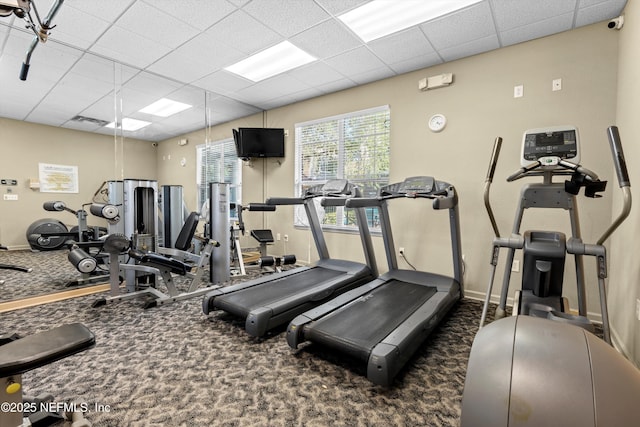 gym featuring a paneled ceiling and dark carpet