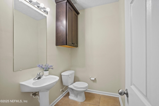 bathroom featuring toilet, a textured ceiling, and tile patterned flooring