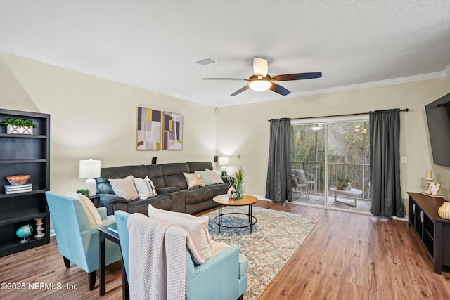 living room featuring light hardwood / wood-style floors, crown molding, and ceiling fan