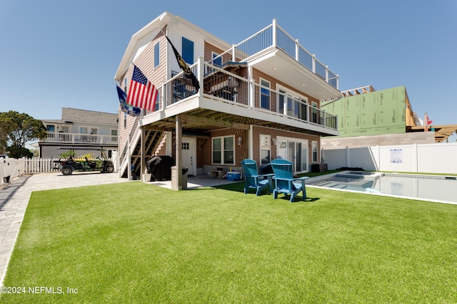 back of house featuring a fenced in pool, a patio area, and a yard