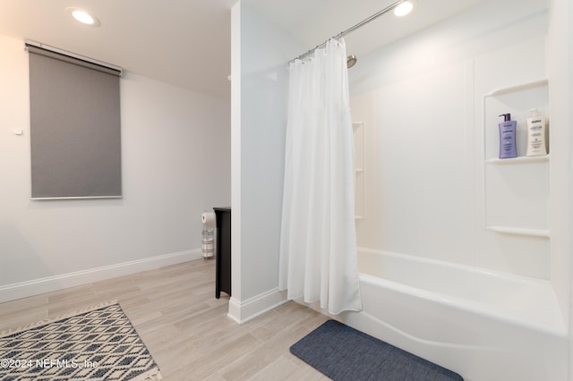 bathroom with hardwood / wood-style floors and shower / bath combo