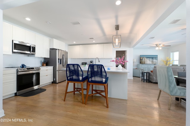 kitchen with white cabinets, light hardwood / wood-style flooring, ceiling fan, and stainless steel appliances