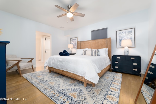 bedroom featuring ensuite bathroom, ceiling fan, and light wood-type flooring