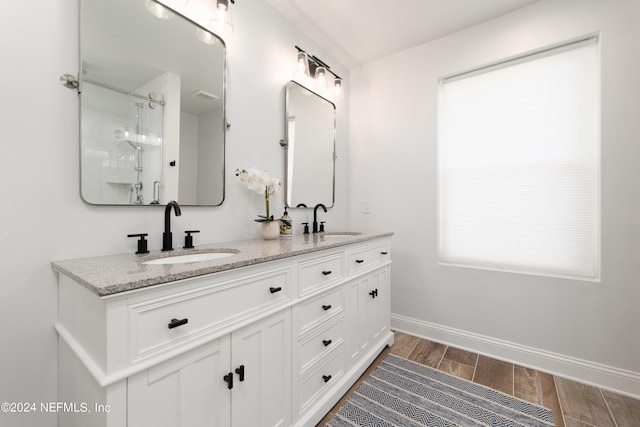 bathroom featuring dual sinks, walk in shower, hardwood / wood-style floors, and large vanity