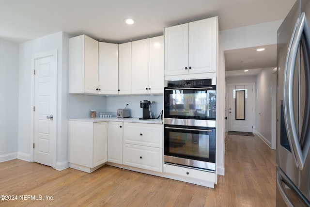 kitchen featuring light hardwood / wood-style flooring, stainless steel appliances, and white cabinetry