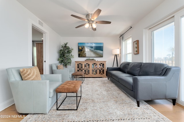 living room with light hardwood / wood-style flooring and ceiling fan