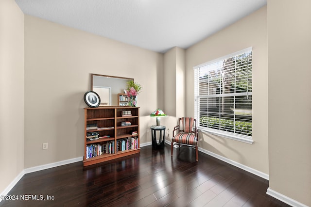 living area featuring plenty of natural light and dark hardwood / wood-style floors