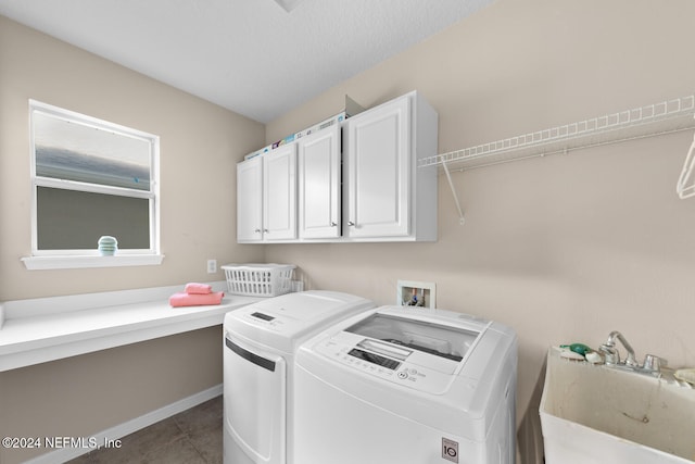 clothes washing area featuring washer and dryer, sink, cabinets, and dark tile patterned flooring