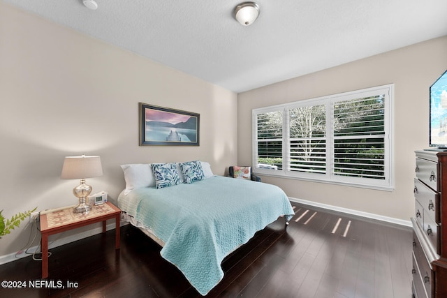 bedroom featuring a textured ceiling and dark wood-type flooring