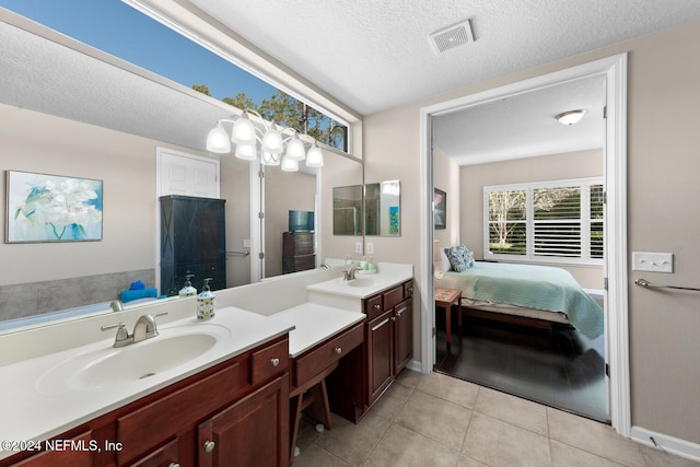 bathroom featuring tile patterned flooring, vanity, and a textured ceiling