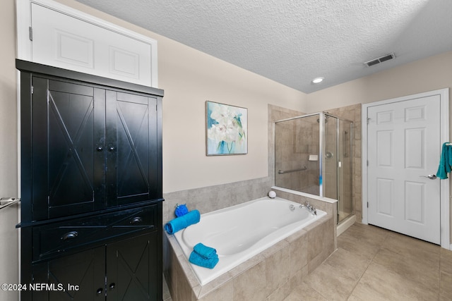 bathroom featuring tile patterned flooring, shower with separate bathtub, and a textured ceiling