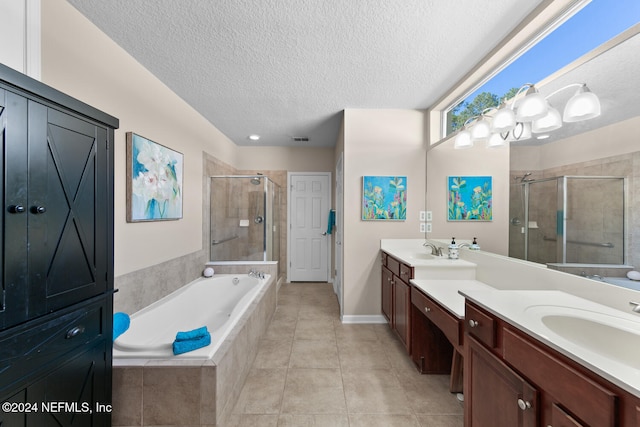 bathroom with tile patterned flooring, vanity, a textured ceiling, and independent shower and bath