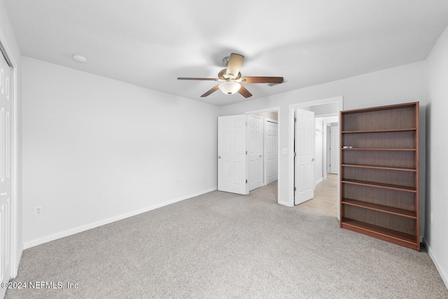 unfurnished bedroom with light carpet, a closet, and ceiling fan