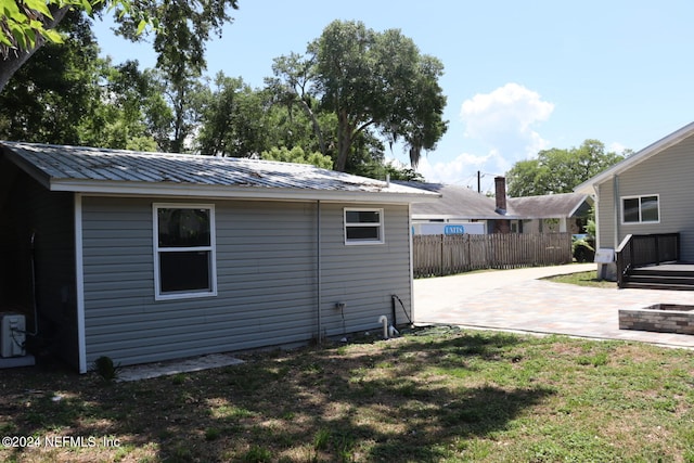 rear view of property featuring a lawn and a patio