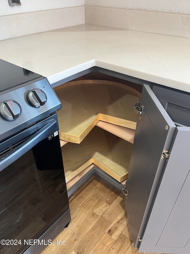 room details featuring black electric range oven and light hardwood / wood-style flooring