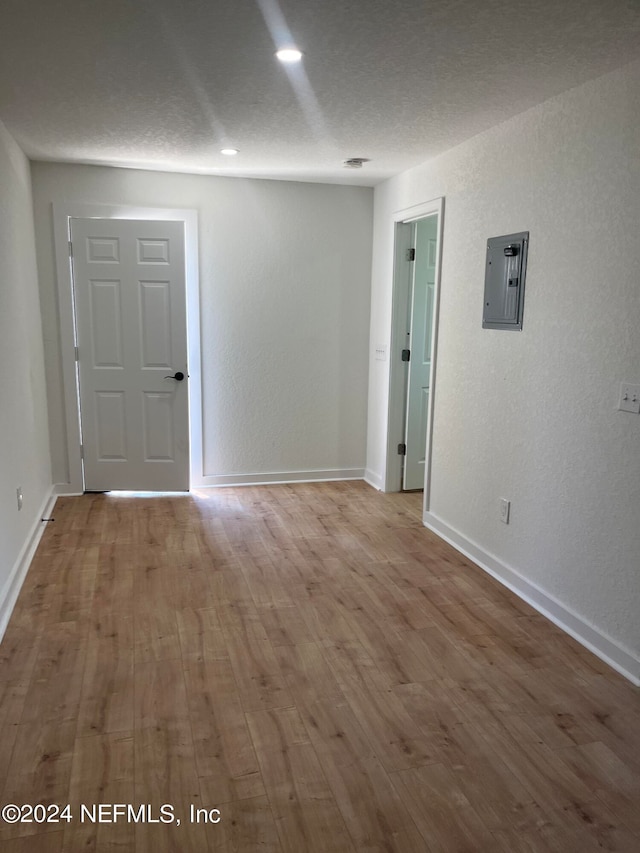 unfurnished room featuring wood-type flooring and a textured ceiling