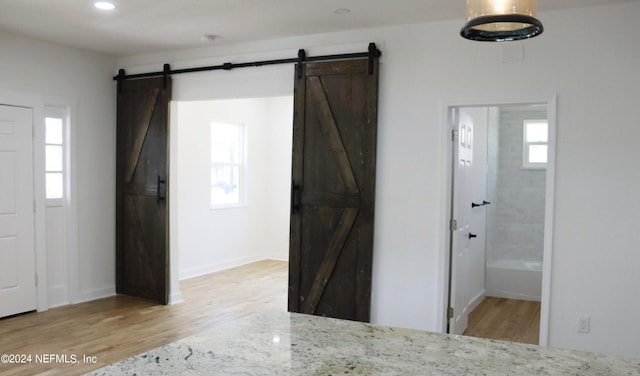 foyer entrance with a barn door and hardwood / wood-style floors