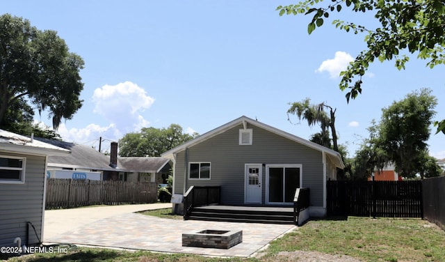 back of house featuring a patio, an outdoor fire pit, and a deck