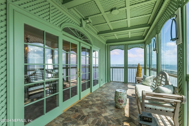 sunroom / solarium featuring a water view