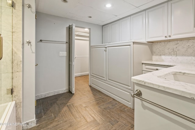 interior space featuring dark parquet floors and a drop ceiling