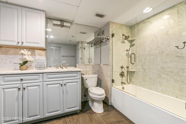 full bathroom with vanity, enclosed tub / shower combo, and toilet