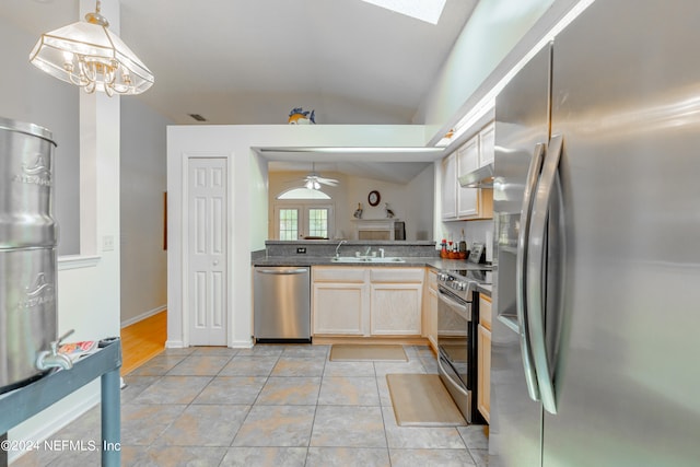 kitchen featuring light hardwood / wood-style floors, stainless steel appliances, decorative light fixtures, lofted ceiling with skylight, and ceiling fan